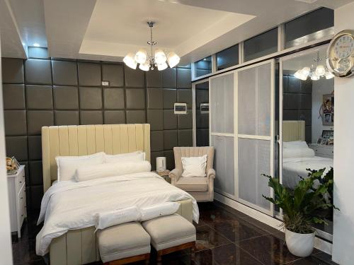 1 dormitorio con cama, silla y espejo en Vitasolo Hometel & Suite en Tagum