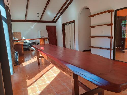 een grote houten tafel in de woonkamer bij House Manantial de Vida in Nandayure