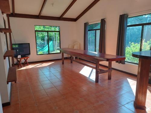 Nandayure的住宿－House Manantial de Vida，一间带木桌和窗户的用餐室