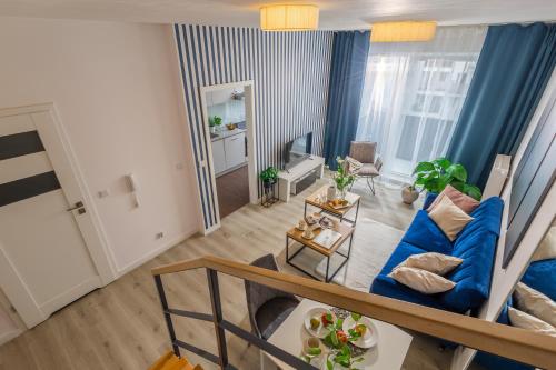 an overhead view of a living room with a blue couch at Apartment Dąbrowskiego by The Railway Station Wroclaw in Wrocław