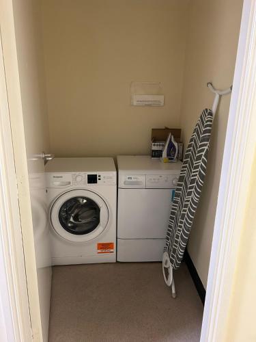 a laundry room with a washing machine and a washer at Bigg Market Apartments in Newcastle upon Tyne