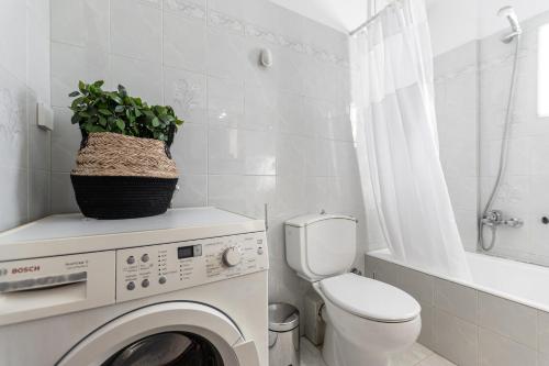 a bathroom with a washing machine and a toilet at Nick & Debbie's two-storey apartment in Mélanes