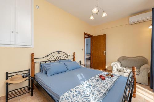 a bedroom with a blue bed and a chair at Nick & Debbie's Two-Storey Apartment in Mélanes