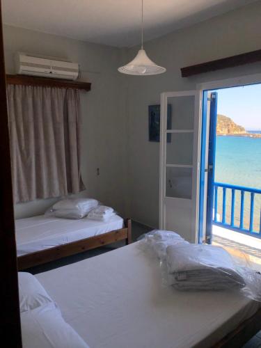 1 dormitorio con 2 camas y vistas al océano en Petradi Sifnos, en Platis Yialos Sifnos