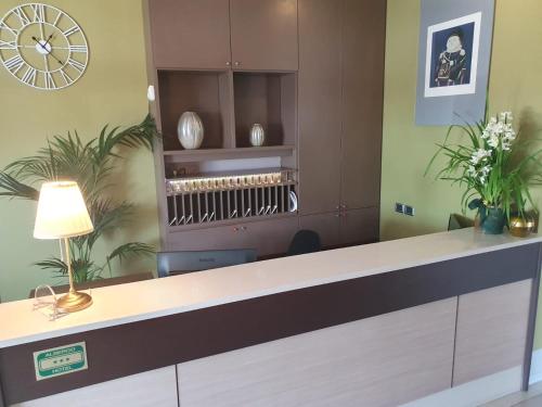 a reception desk in a office with a clock on the wall at eq hotel in Travagliato