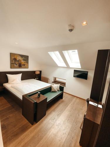 a bedroom with a bed and a skylight at Hotel Hofwirt Neubeuern in Neubeuern