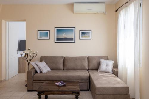 a living room with a couch and a coffee table at White Holidays Project Ag. Sostis in Agios Sostis