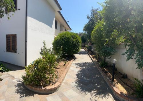 a garden with trees and bushes next to a building at Villetta Saba in Olbia