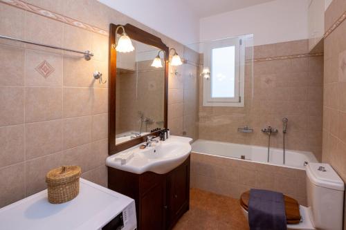 La salle de bains est pourvue d'un lavabo, d'une baignoire et de toilettes. dans l'établissement White Holidays Project Ag. Sostis, à Agios Sostis