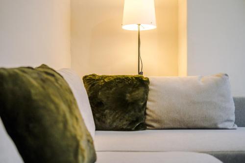 ein Sofa mit zwei Kissen und einer Lampe drauf in der Unterkunft Quirky Townhouse Near City - Beach Free Parking in Wallasey