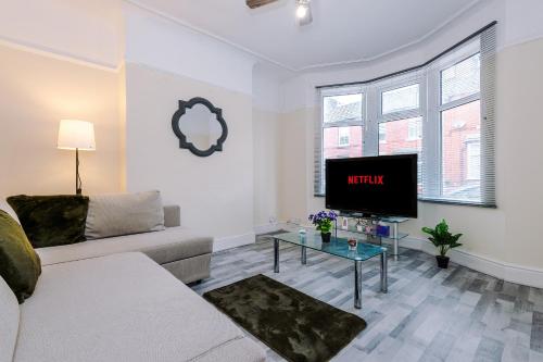 a living room with a couch and a tv at Beautiful Townhouse Free Parking - Near City and Beach with Fast W-FI in Wallasey