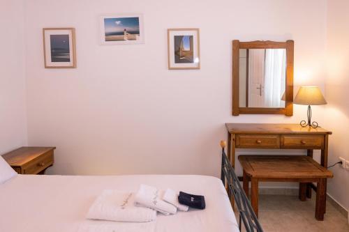 a bedroom with a bed and a mirror and a table at White Holidays Project Ag. Sostis in Agios Sostis