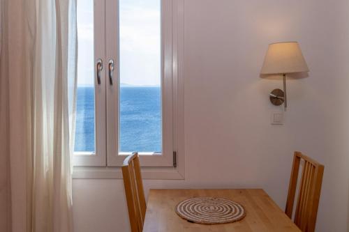 a dining room with a table and a window at White Holidays Project Ag. Sostis in Agios Sostis