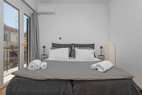 - une chambre avec un grand lit et des serviettes dans l'établissement Avenue Apartment Corfu Town, à Ágios Rókkos