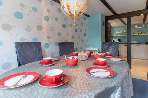 a table with red cups and plates on it at Ferienhaus Hermine in Tönning