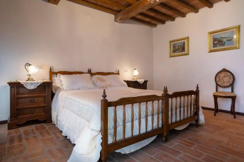 1 dormitorio con 1 cama grande y 1 silla en Tenuta I Mandorli, en Peccioli