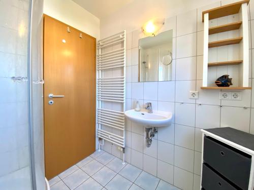 ein Bad mit einem Waschbecken und einem Spiegel in der Unterkunft Dünenresidenz Karlshagen - Ferienwohnung Lindenweg 8b in Ostseebad Karlshagen