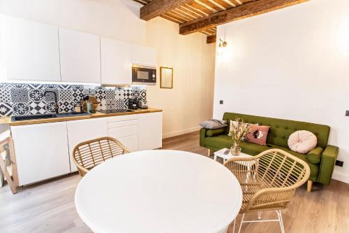 - un salon avec une table blanche et un canapé vert dans l'établissement Douceur au coeur du Panier, à Marseille