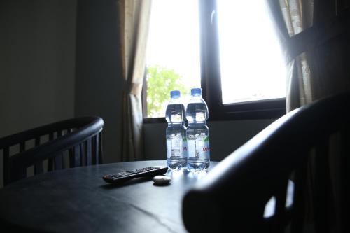 dos botellas de agua y un mando a distancia en una mesa en Cemara Guest House Syariah Kertajati, 