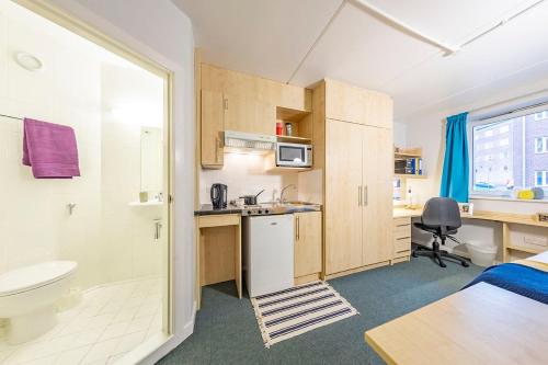 a room with a bathroom with a bed and a sink at Modern City Living Apartments at Broadgate Park in Nottingham in Nottingham