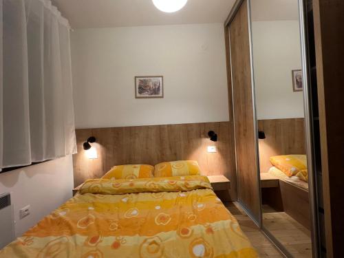a bedroom with a bed and a mirror at Apartman Gnezdo - Titova vila Zlatibor in Zlatibor