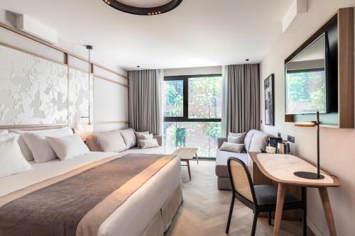 a bedroom with a large bed and a living room at Barceló Funchal Oldtown in Funchal