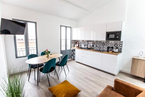 une cuisine et une salle à manger avec une table et des chaises dans l'établissement Magnifique Duplex 2ch / 2 sdb, à Marseille
