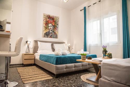 um quarto com uma cama com uma colcha azul em Artzy petit apartment close to the center em Heraclião