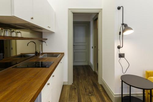 a kitchen with white cabinets and a sink and a table at Palazzo Fontana in Trevi