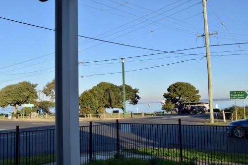a view from a window of a street with a fence at Beachside Getaway Bay Views North Shore VIC Sleeps 12 Free Wifi in North Shore
