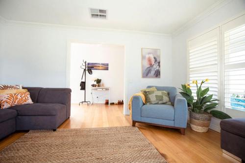 a living room with a couch and a chair at Beachside Getaway Bay Views North Shore VIC Sleeps 12 Free Wifi in North Shore