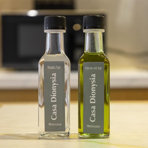 two bottles of olive oil and vinegar sitting on a table at Casa Dionysia - New Lux 2Br with Jacuzzi near Maleme Beach in Maleme