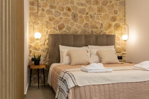 1 dormitorio con 1 cama grande y pared de piedra en Luxury New House near the Beach! - Casa Dionysia en Maleme