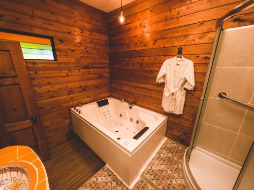 a bathroom with a tub and a shirt hanging on a wall at Casa Morasan Hotel-Boutique in Quetzaltenango