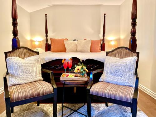 a bedroom with a bed with a table and two chairs at Settlers Suites in Niagara on the Lake