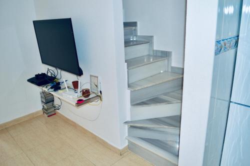 Habitación con escaleras y TV en la pared en Refugio de Tranquilidad en Gran Alacant, en Gran Alacant