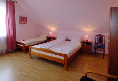 Family Homes - Bed & Bike Guesthouse في Łebcz: غرفة نوم بسريرين ومصباحين في المواقف الليلية