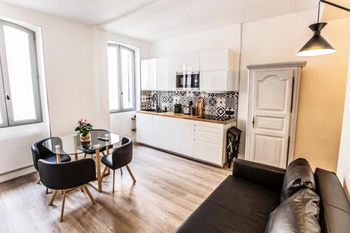 een woonkamer met een bank en een tafel bij Belle rénovation moderne au coeur du Panier in Marseille