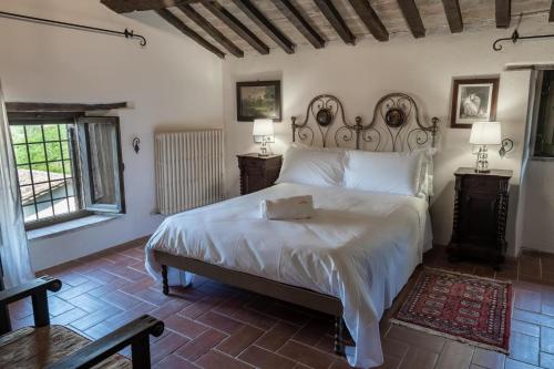 a bedroom with a large white bed and two windows at Life Hotels Abbazia San Faustino Resort in Pietralunga