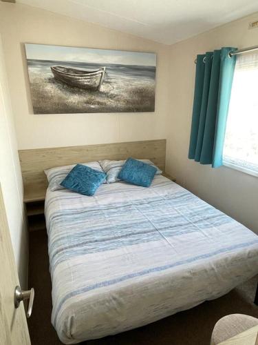 a bed in a bedroom with a picture of a boat at Lizard ,Mullion holiday caravan in Mullion