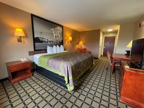 a hotel room with a bed and a flat screen tv at Super 8 by Wyndham Rolla in Rolla