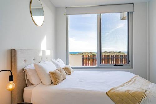 um quarto com uma cama e uma janela grande em Luxury Beach Front Apartment Moana - Waterviews em Moana