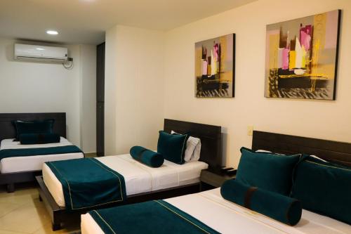 麥德林的住宿－hotel medellin gold，酒店客房设有两张床,墙上挂有绘画作品