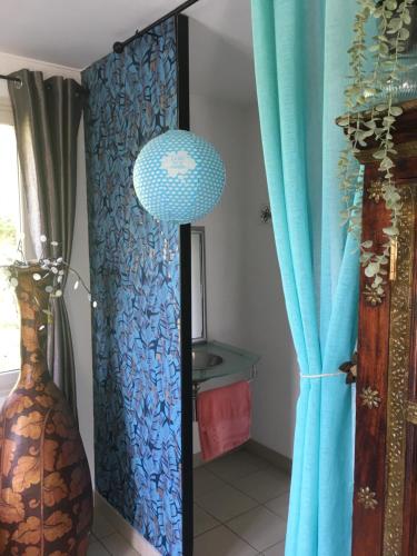 une chambre avec un rideau bleu et une lampe dans l'établissement Studio à la campagne, à Bouloire