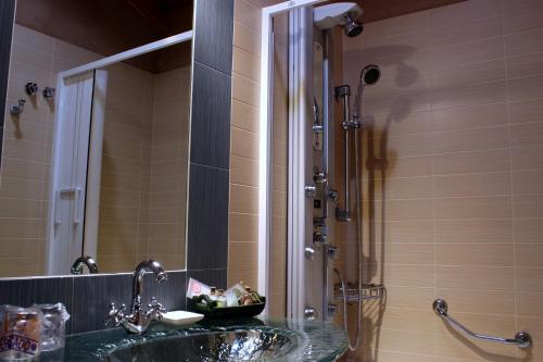 a bathroom with a sink and a shower with a mirror at Las Fontaninas in Noceda del Bierzo