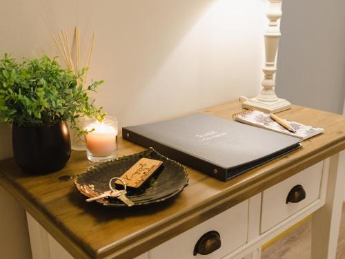 a desk with a laptop computer and a candle and a candle at Durham Riverside Apartments in Durham