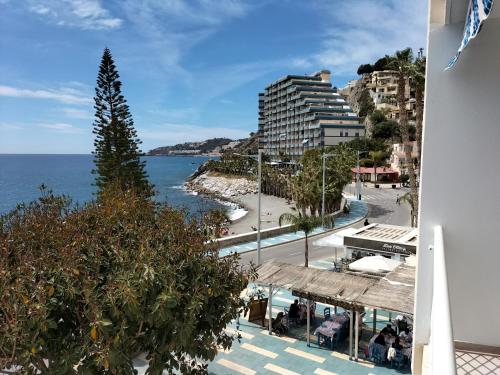 uitzicht op het strand vanaf het balkon van een gebouw bij Delfin Home in Almuñécar