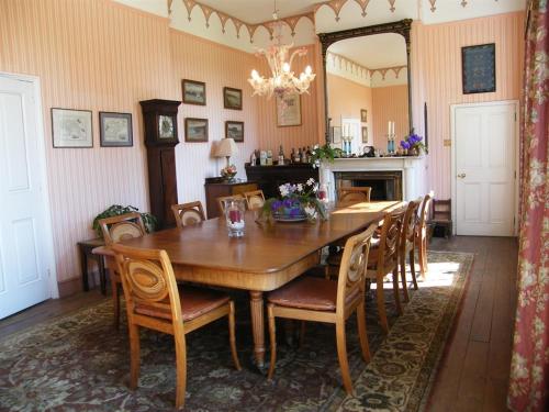 a dining room with a wooden table and chairs at Glebe House Muston in Muston