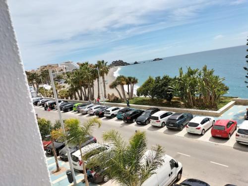 rząd samochodów zaparkowanych na parkingu obok oceanu w obiekcie Delfin Home w Almuñécar