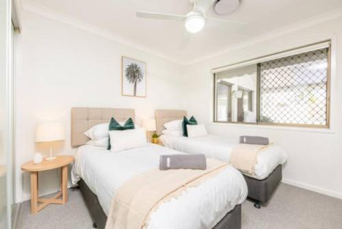 a bedroom with two beds and a window at Mooloolaba Escape to Mooloolaba & Feel At Home in Style in Mooloolaba